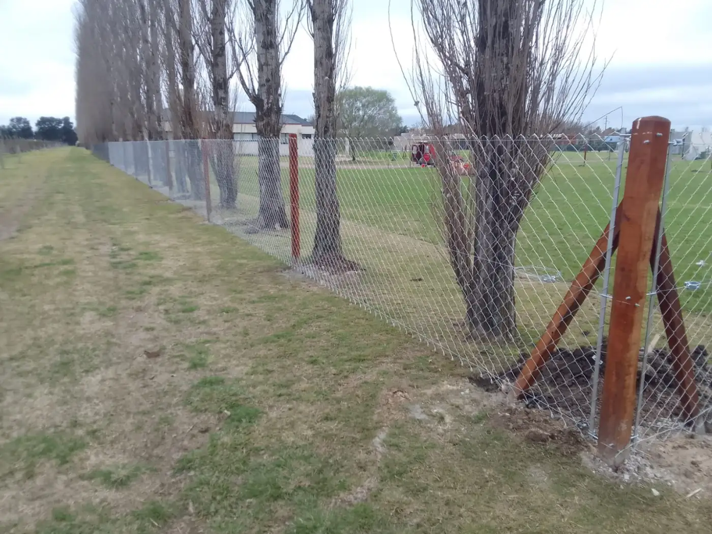 Cercado de terreno con alambrado olimpico y postes de madera en Rosario